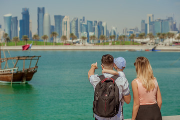 Fototapeta na wymiar tourist european family looks at the skyscrapers West Bay in Doha, Qatar