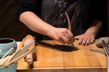 making objects with clay and tools. close up cropped photo about ceramics.