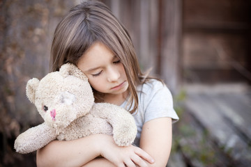 Little Girl Holding Ragged Teddybear Outside - Poverty, Homelessness