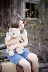 Little Girl Holding Ragged Teddybear Outside - Poverty, Homelessness