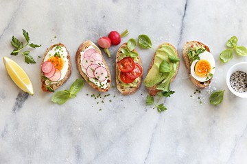 Breakfast sandwich bread with avocado, egg, radishes and tomatoes. Bruschetta or healthy snack ideas - obrazy, fototapety, plakaty