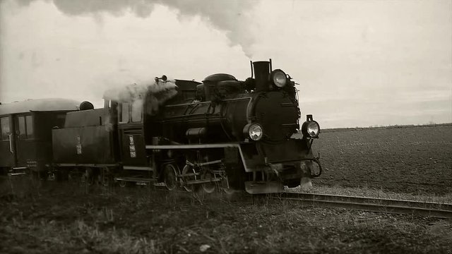 Old passangers train running on the tracks. Retro locomotive with steam engine loopable black and white footage.