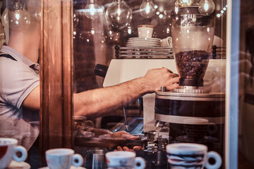 The barista working in a trendy coffee shop, outside view