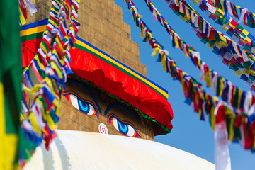 Fototapeta na wymiar Boudhanath in Nepal. Cultural heritage in Kathmandu. The Biggest Tibetan temple. Nepalese prayer flags. Image of eyes close up