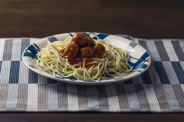 Spaghetti with meatballs in tomato sauce and fresh fruits
