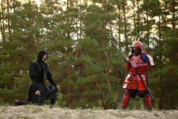 Samurai fight with ninjas on a background of forest and sand