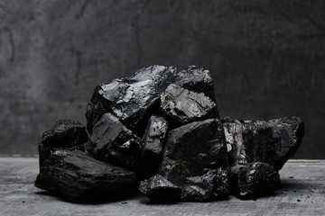 Natural coal on a black background isolated closeup. Extraction of natural mineral resources.