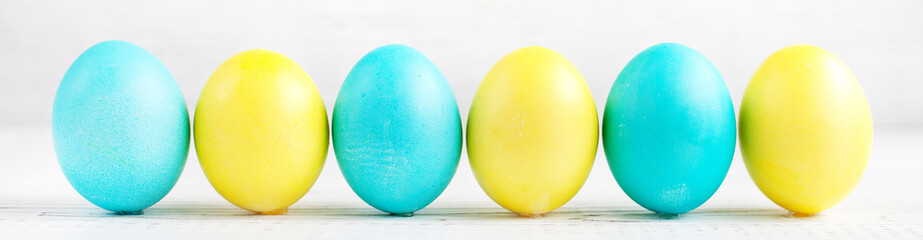 Blue and yellow eggs on a white background. Concept Happy East