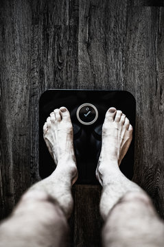 Legs of man using weight scale