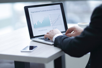 businessman working on laptop with financial documents