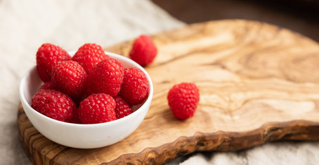 Fresh Raspberries In A Bowl On Linen Background, Space For Text