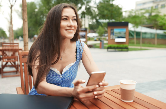 Woman sitting at outdoor cafe table