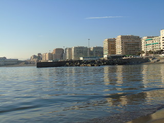 Obraz premium Genova, Italy - 02/14/2019: An amazing caption of the sunset over the sea and the city of Genoa in winter days and great views to the old buildings near the beach coloured by the sun