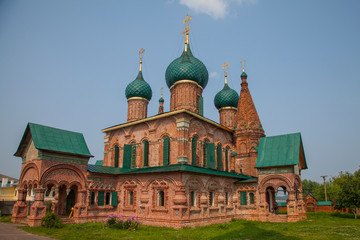 Fototapeta na wymiar Old orthodox church of red brick with green domes