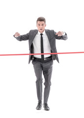 Happy businessman running through finishing line.