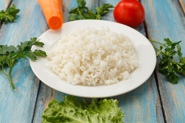 plate of rice with fresh vegetables on the background