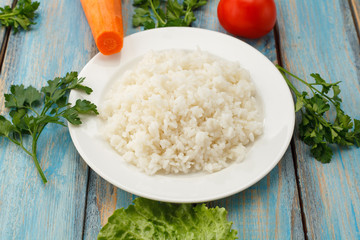 plate of rice with fresh vegetables on the background