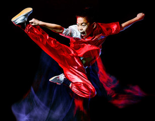wushu chinese boxing kung fu Hung Gar fighter isolated child isolated on black background with speed light painting effect motion blur