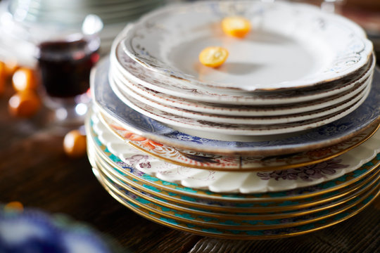 Stack of Patterned Plates with Glass of Wine and Kumquats