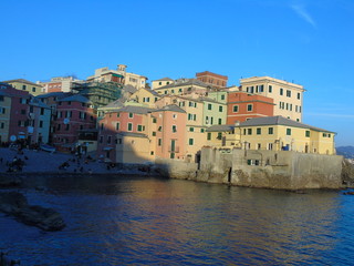 Genova, Italy - 02/14/2019: An amazing caption of the sunset over the sea and the city of Genoa in winter days and great views to the old buildings near the beach coloured by the sun