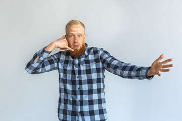 Freestyle. Mature man standing isolated on grey showing call gesture looking camera confused