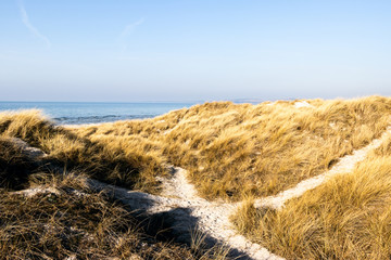 landscape with sand dunes, sea and blue sky
