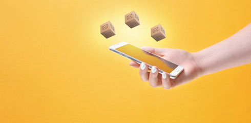 Woman holding smartphone surrounded with mail icons on yellow background