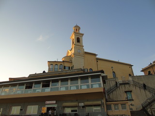 Genova, Italy - 02/14/2019: An amazing caption of the sunset over the sea and the city of Genoa in winter days and great views to the old buildings near the beach coloured by the sun