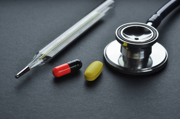 Stethoscope, Thermometer and Pills.