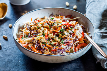 Warm rice salad with grated vegetables, peanut sauce and peanuts