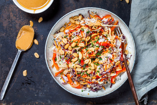 Warm rice salad with grated vegetables, peanut sauce and peanuts