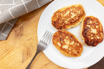 Russian syrniki or sirniki, homemade cottage cheese fritters or pancakes. breakfast with curd pankakes, top view