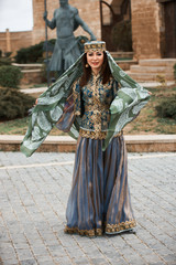 Fototapeta na wymiar Beautiful woman wearing oriental national clothes posing outdoor