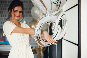 Brunette bride showing hand with wedding ring and hiding face. Woman holding hand, showing ring from her groom, celebrating hen party in hotel. Concept of celebrating.