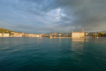Fototapeta premium Sunrise view of the Riva Promenade, the Split Cathedral Tower and the old town section of Split, Croatia from the harbor on the Adriatic Sea