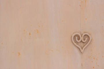 Metal heart shape on the metallic surface with rust, texture with defects