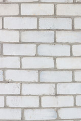 Old white brickwork with different defects, shabby texture