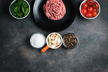 Mince. Shredded meat with ingredients fresh vegetables and spices for cooking on a black background. Top view copy space.