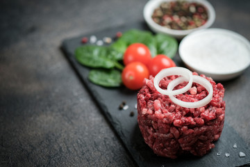 Mince. Shredded meat with ingredients fresh vegetables and spices for cooking on a black background. Top view copy space.