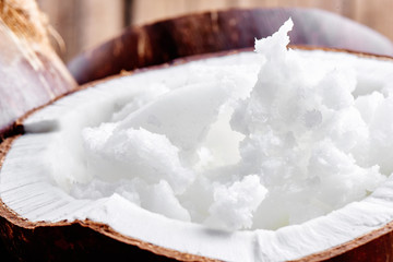 Vietnamese brown coconuts with coconut oil inside on wooden background