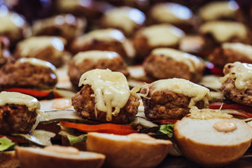 Closeup View of Sliced Bread Spread on the Table with Ingredients on them for Small Burgers - Kitchen Set, Concept of the Holiday Evening Dinner Table