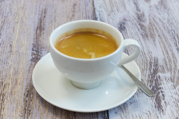 white Cup of coffee on a wooden table close-up. black coffee with milk. wooden table with a fragrant drink.