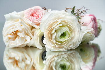 Bouquet of white roses lying on the mirror. Closeup.