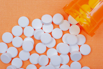 Non-steroidal anti-inflammatory drugs. Acetaminophen white tablets on orange background. 