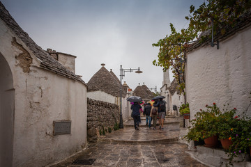 Fototapeta na wymiar Tourists in the rain as they visit the streets of the village