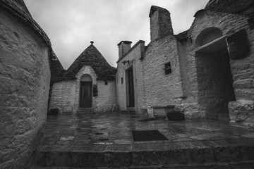 Black and white effect of  Trulli of Alberobello in a small square on a rainy day