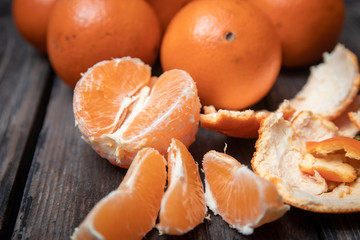 Fresh orange fruit whole and sliced, with peel on old wooden table