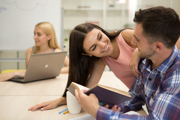 Man sitting with book in hand, distracting from reading by girl.