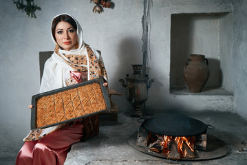Beautiful Woman holding tray with  baklava dessert, indoors