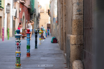 Fototapeta na wymiar Bolardos pintados y dibujados de diferentes colores en una calle de Tarragona. España